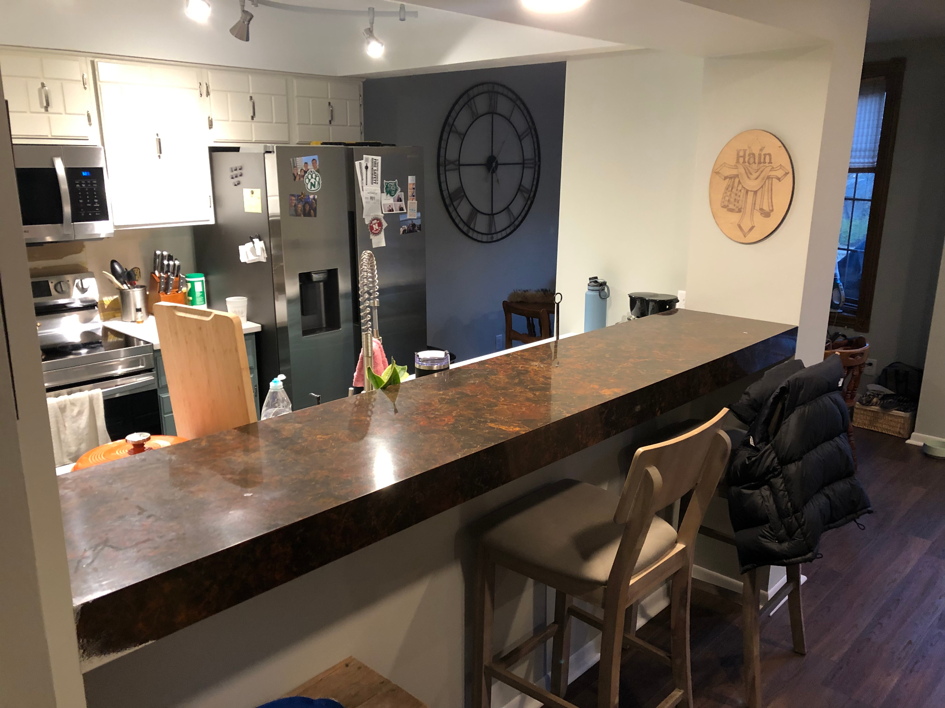 Kitchen pass-through bar top finished in a poured epoxy with swirling copper, bronze, and dark brown tones