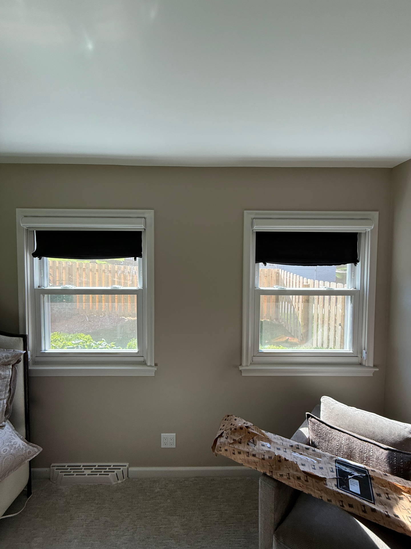Two bedroom windows fitted with matching black roller shades mounted inside the window frames